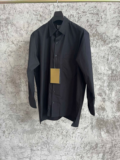 A simple long-sleeved single-breasted shirt with a double-layered collar, solid color and asymmetrical design